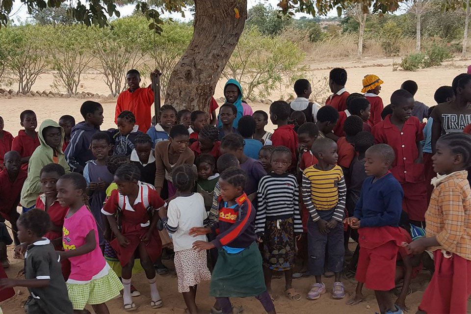 Group of children gathering outdoors in a rural area